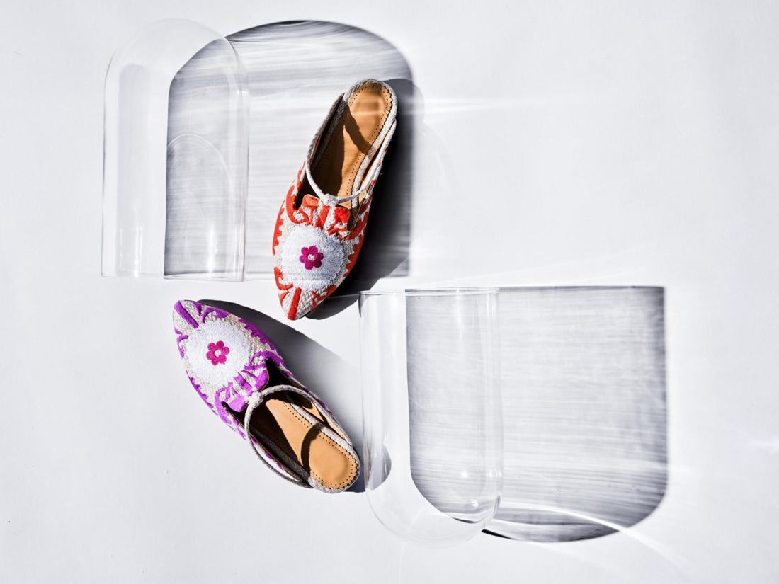 Red and purple embroidered pointed shoes on sculptural glass