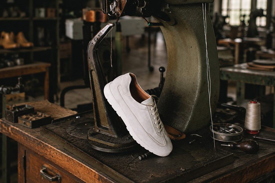 White sneakers beside footwear manufacturing machinery